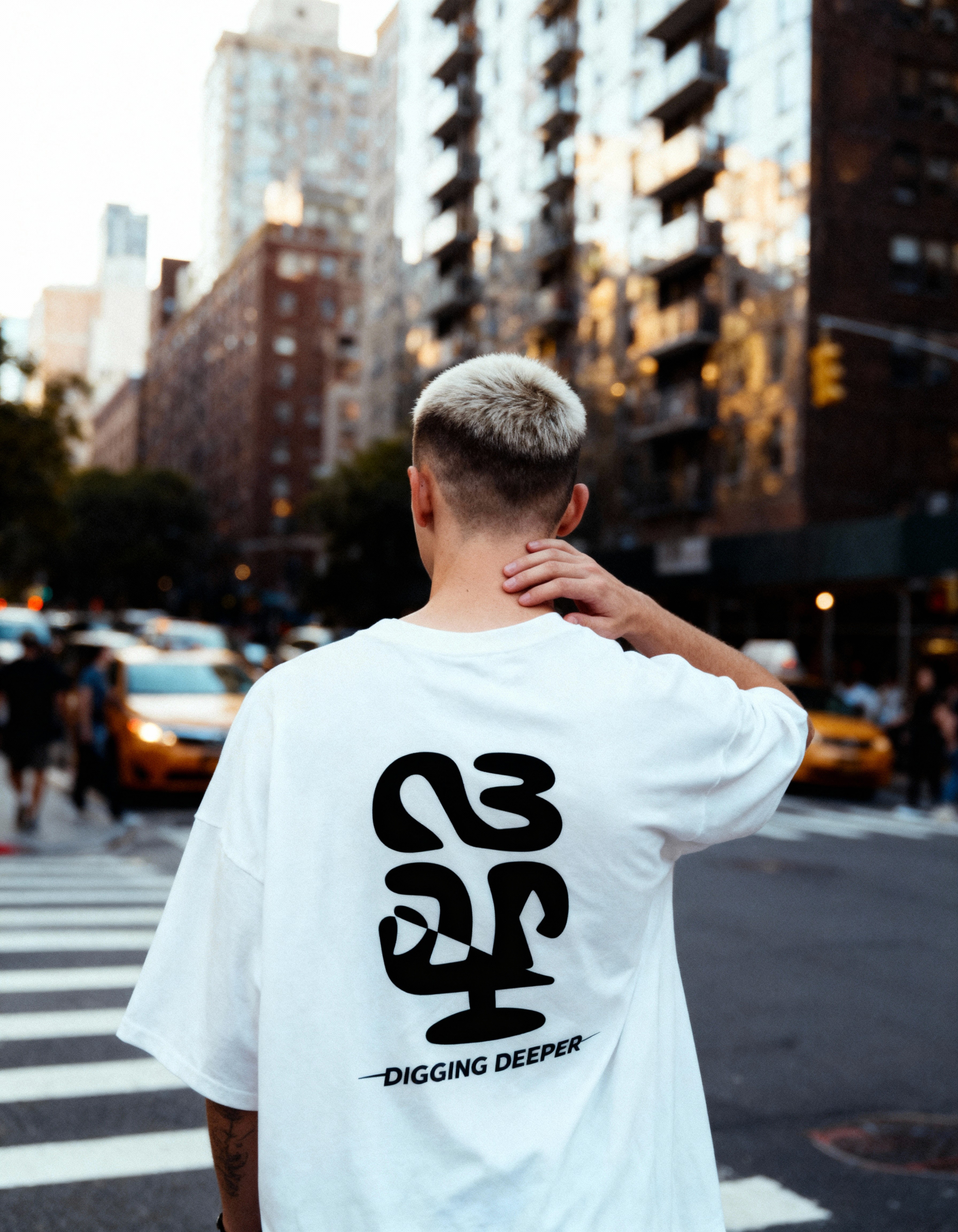 Branded T-shirt — NBAP Digging Deeper logo on a white oversized tee, street photography